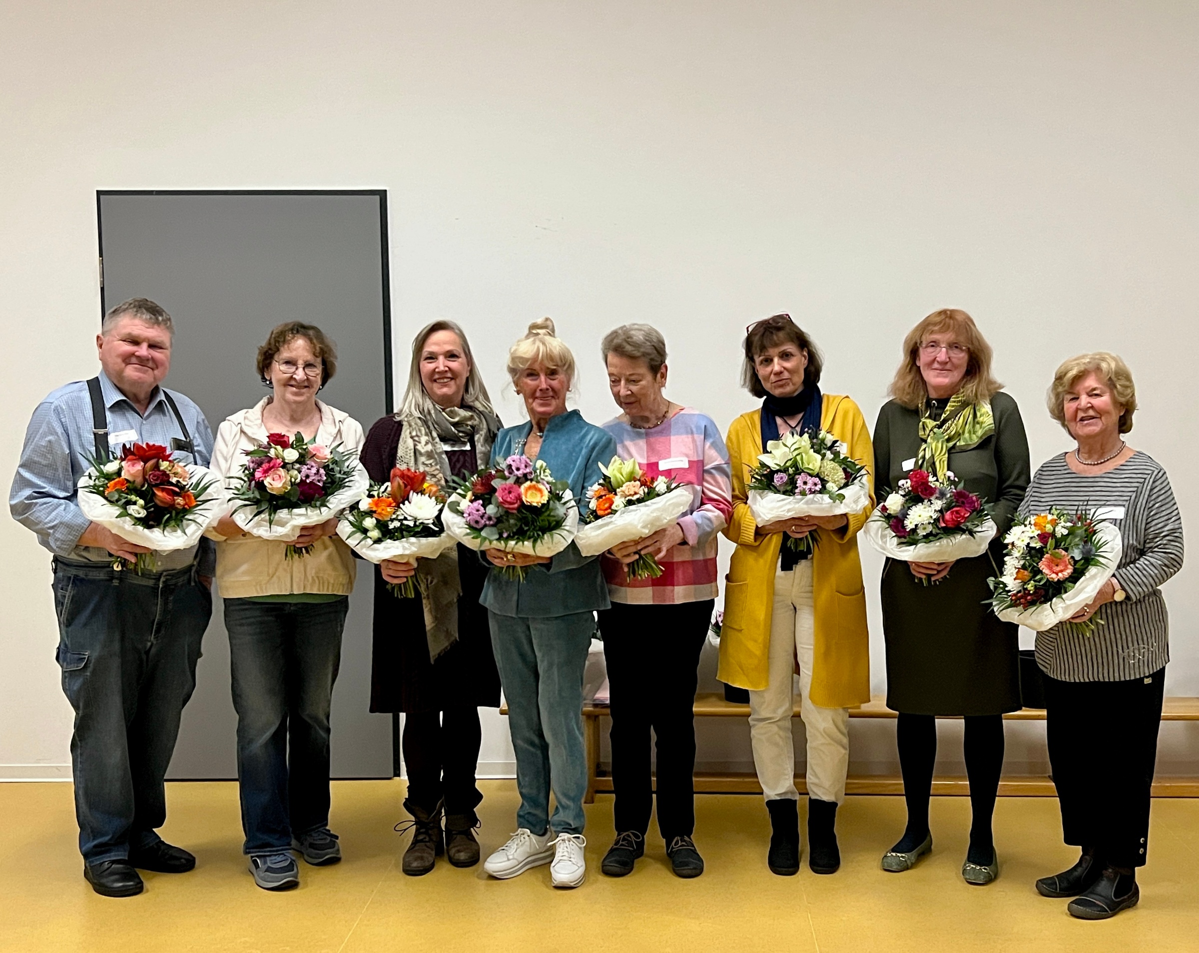 Acht Dozierende halten nach ihrer Ehrung beim Dozierendenfest Blumensträuße in ihren Händen.